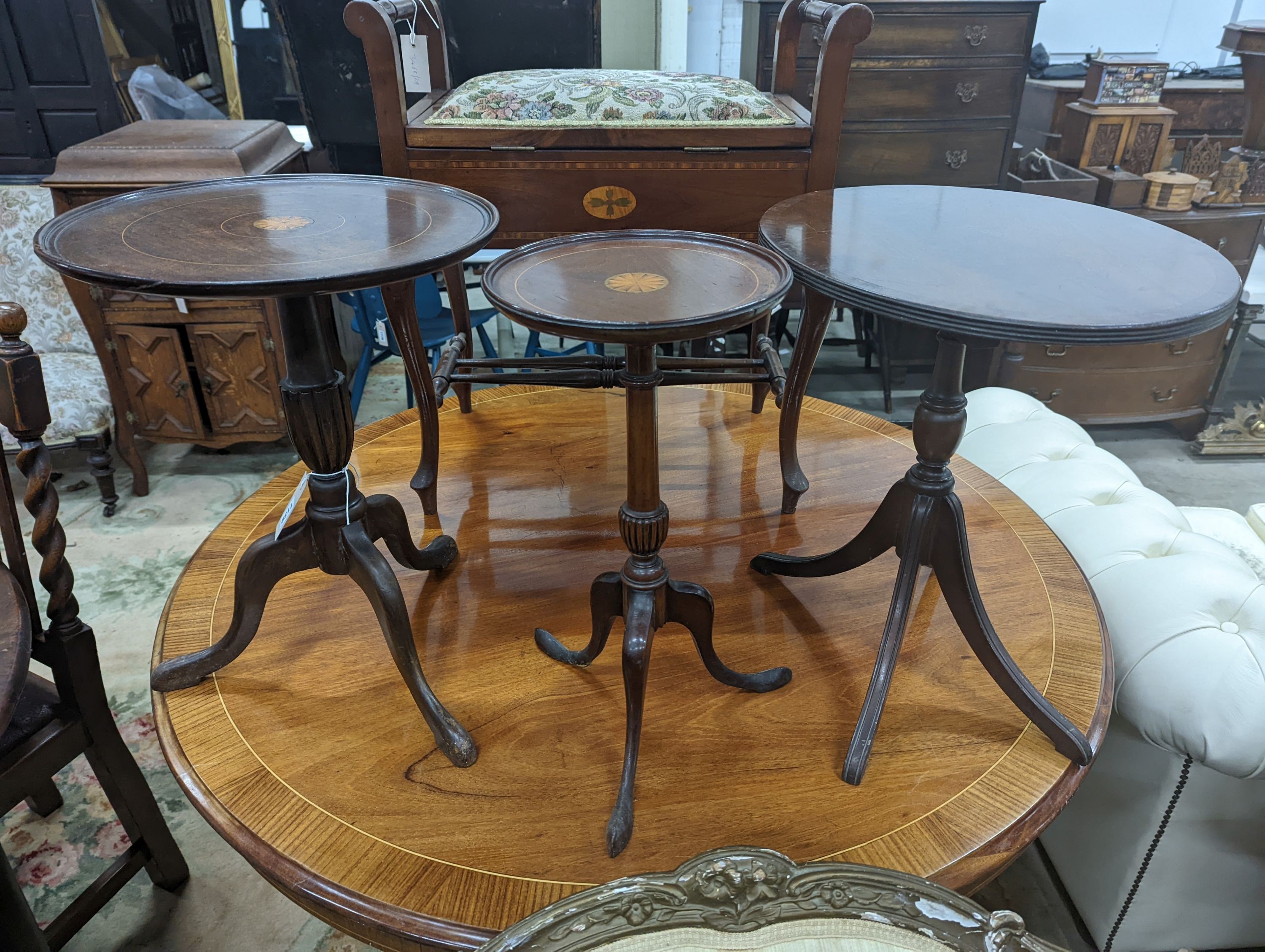 Two Edwardian inlaid mahogany tripod wine tables, larger height 50cm, together with a later folding oval wine table (3)